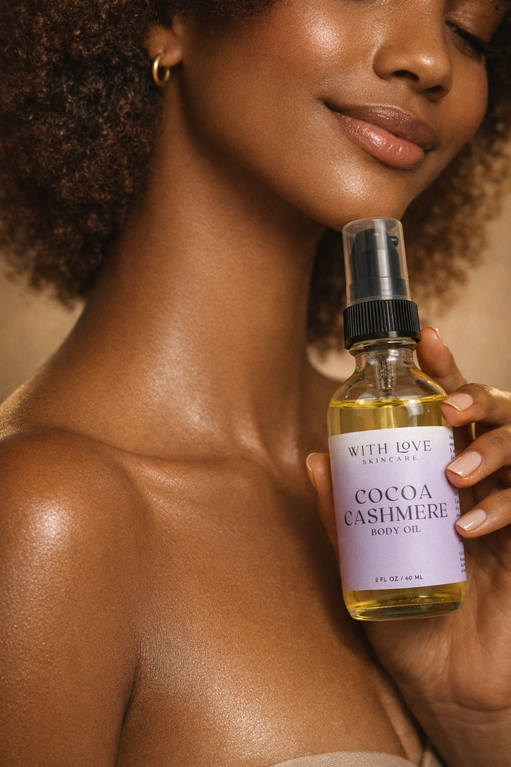Woman holding a bottle of 'Cocoa Cashmere' body oil with a blurred background